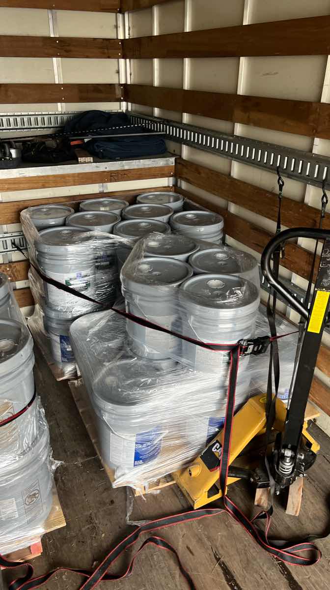 Palletized freight strapped down inside a box truck cargo bay