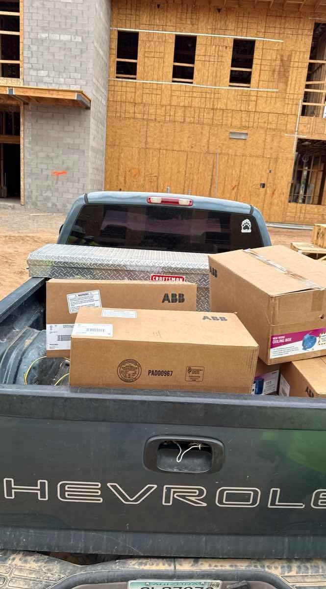 Chevrolet pickup truck bed loaded with ABB and Craftsman cardboard boxes at a construction site for a Curri same-day delivery