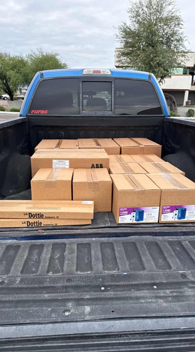 Blue pickup truck loaded with ABB and LH Dottie electrical-supply boxes for a Curri industrial run