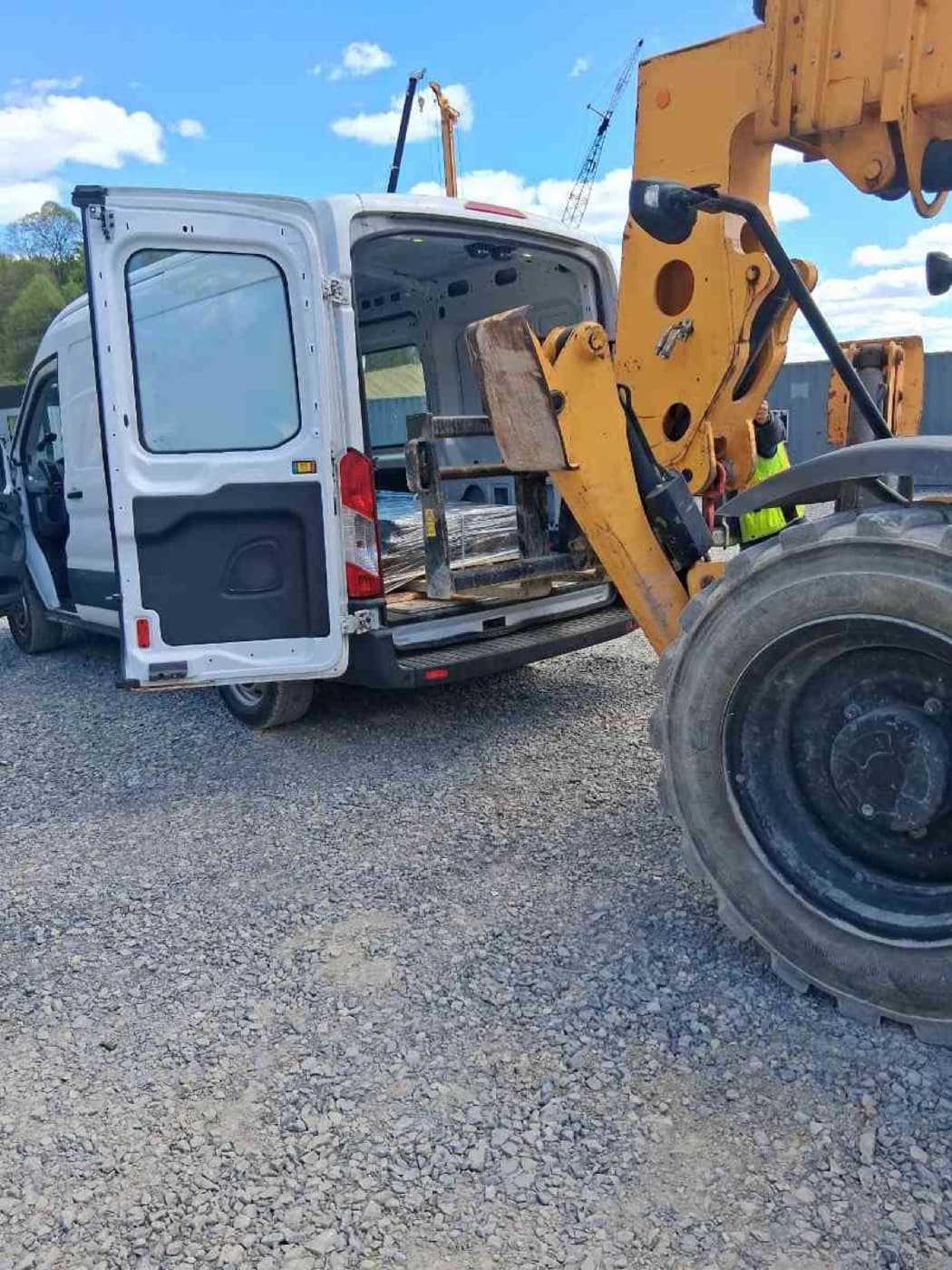Telehandler loading a palletized order into a white Sprinter Van for a Curri industrial-supply delivery