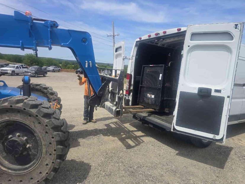 Blue forklift loading a wrapped pallet into the rear of a white Sprinter Van for a Curri same-day distribution route