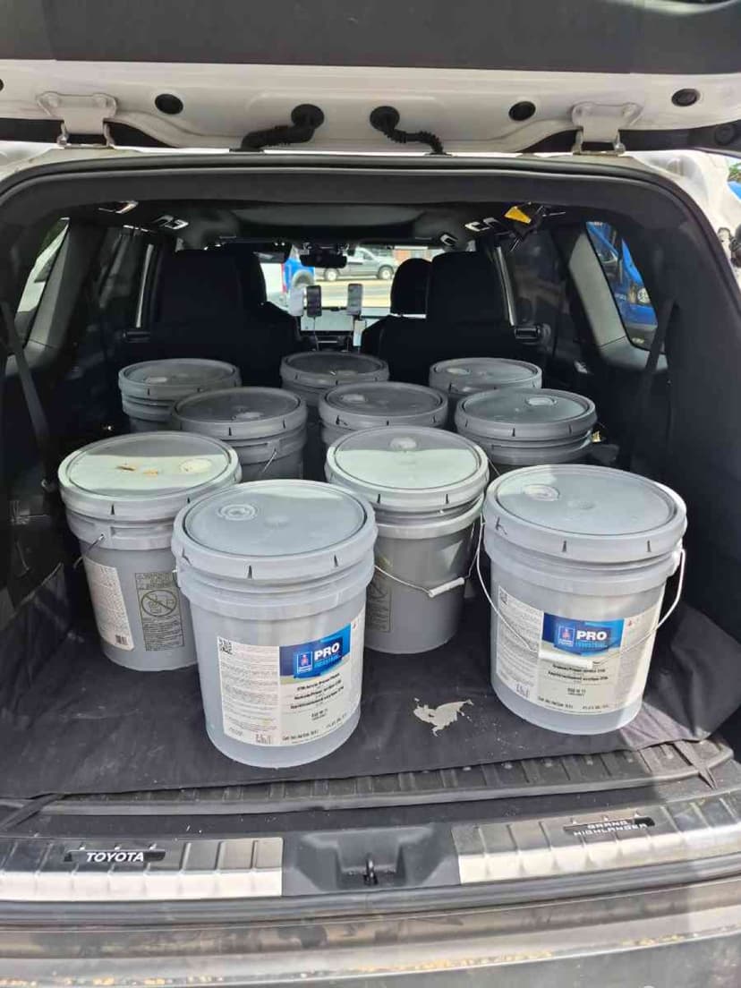 Toyota Highlander trunk loaded with 5-gallon Sherwin-Williams paint pails for a Curri trade-supply pickup