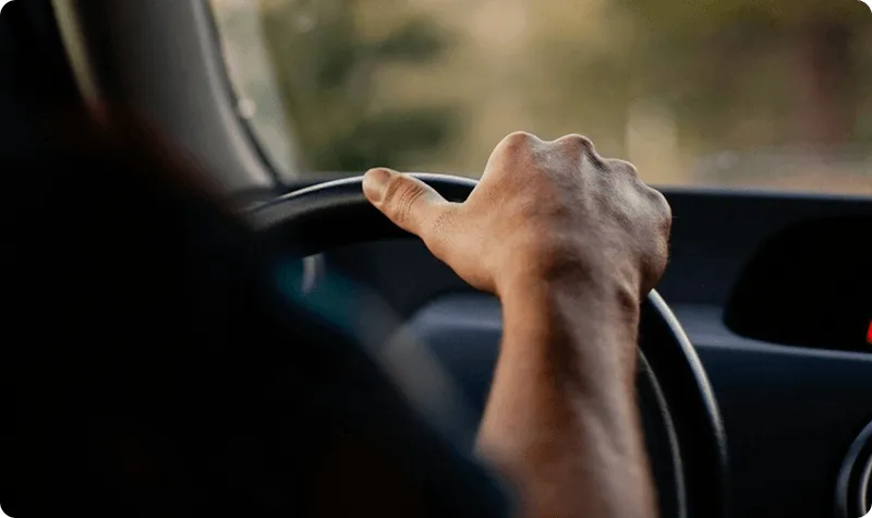 Driver at the wheel of a cargo van on an agriculture final-mile run, moving seed, fertilizer, and ag-supply parts from the distributor out to the farm or rural dealer on Curri's dispatch.