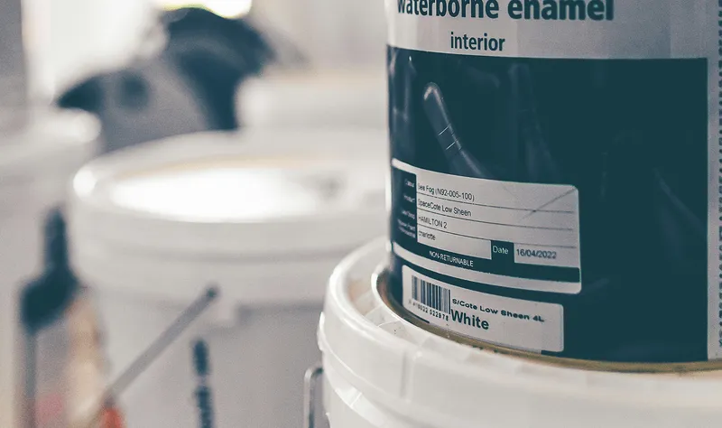 Close-up of a Waterborne Enamel interior paint bucket on a shelf, lid labeled with specs, the kind of architectural and commercial coatings Curri delivers same-day from paint distributors to contractors.